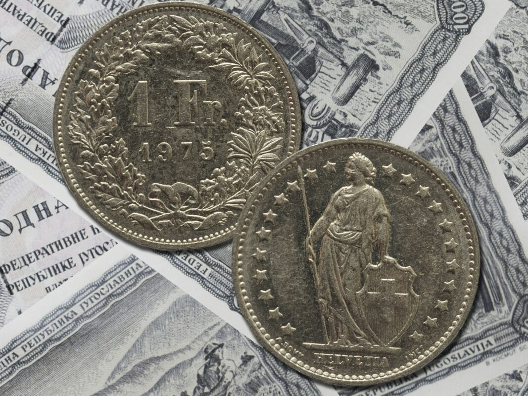 Vintage Swiss franks coin isolated on paper money background