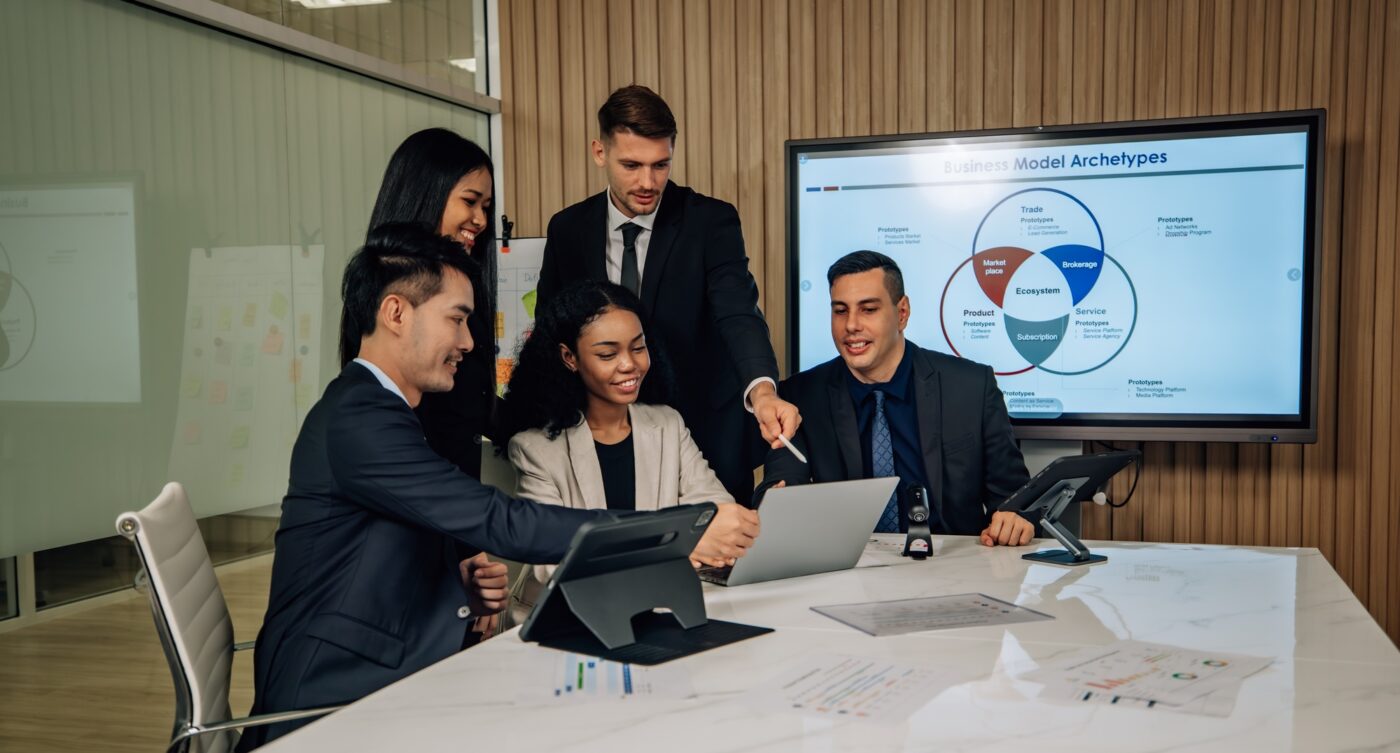 Diverse team innovates for sales KPIs via collaborative brainstorming to develop business models.